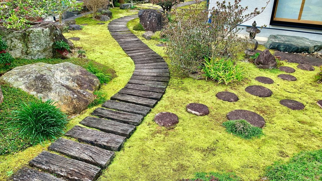 木道と景石の周囲に苔が広がる庭